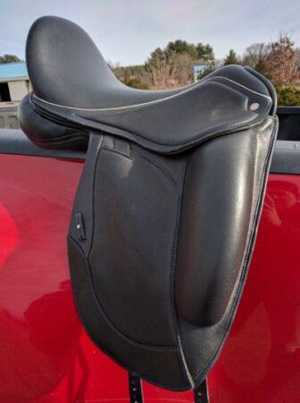 black dressage saddle on a truck railing