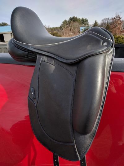 black dressage saddle on a truck railing
