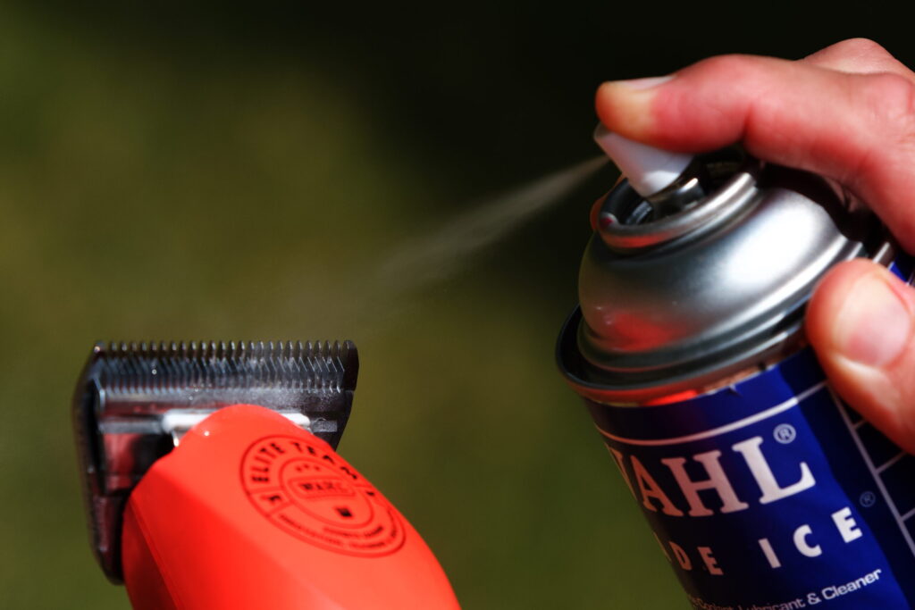 spray can of clipper coolant blade ice being sprayed on a 10w blade of horse clippers 