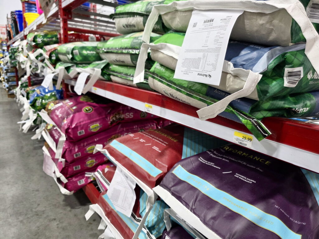 feed bags for horses stacked in clean shelves down an aisle