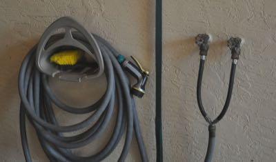 hot water faucets and hose rolled up away from horse legs in wash rack