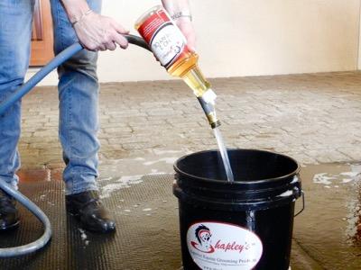 adding grooming oil to a bucket of water