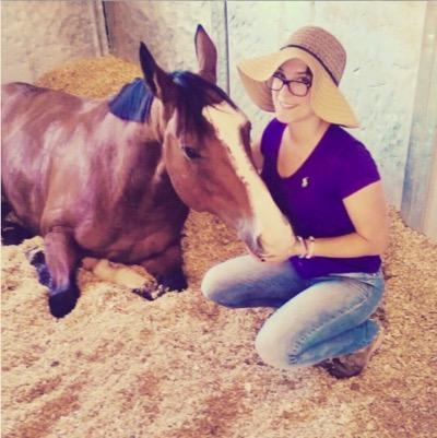 Lauren with a resting horse in a stall
