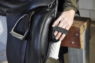 brushing a saddle to clean it