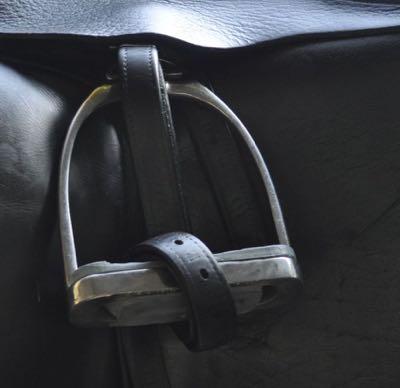 stirrup iron rolled up on black saddle