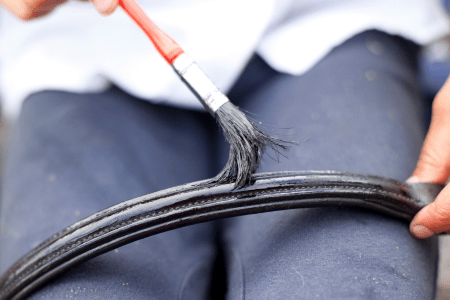 small brush being used to apply neatsfoot oil to a bridle browband