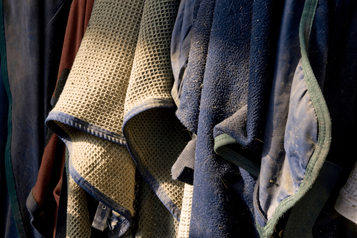 dirty horse coolers and irish knit hanging in barn